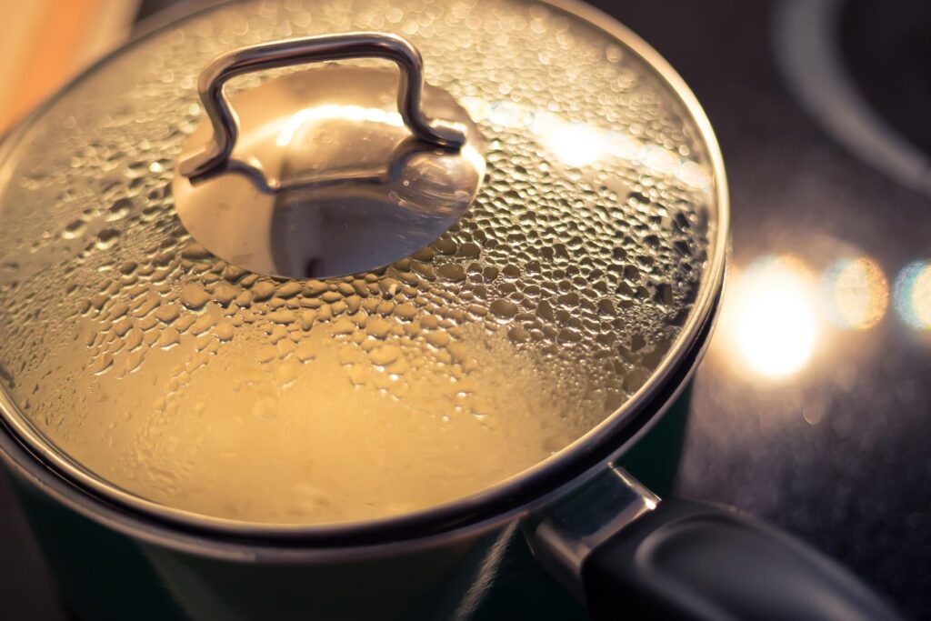 Steaming process of cooking parboiled rice in a pot with a glass lid, retaining moisture for perfect texture. 使用鍋具烹煮益米預熟米的過程，透過玻璃蓋觀察米飯吸飽水分與蒸氣循環。