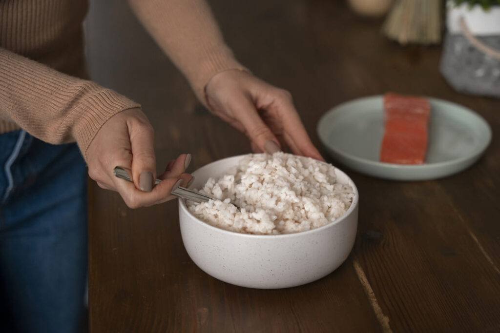 A close-up of a perfectly cooked bowl of glistening EatMe parboiled rice, a healthy starch for elder energy. 餐桌上一碗晶瑩剔透的益米預熟米飯特寫,口感軟嫩、膳食纖維豐富,是銀髮族健康澱粉的首選。