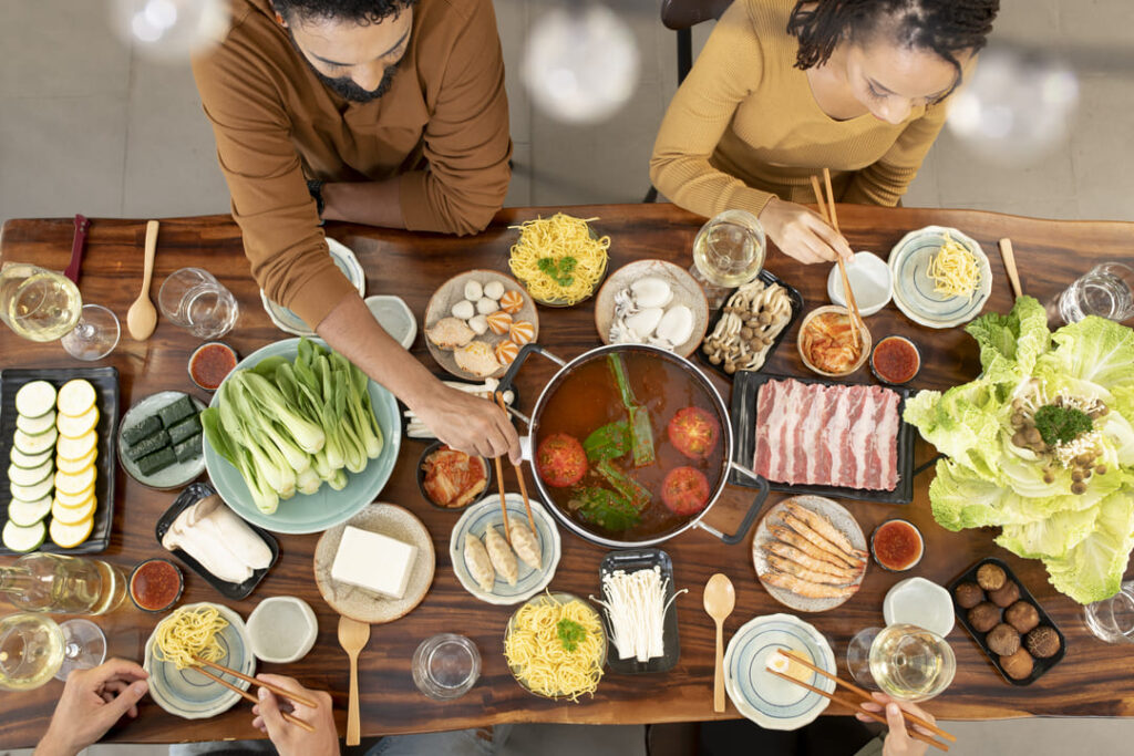 A table set with a healthy hotpot meal featuring various vegetables and meats, perfect for senior nutrient diversity. 一桌擺滿蔬菜與肉品的健康火鍋料理,方便銀髮族長輩選擇多樣化且容易烹煮的食材。